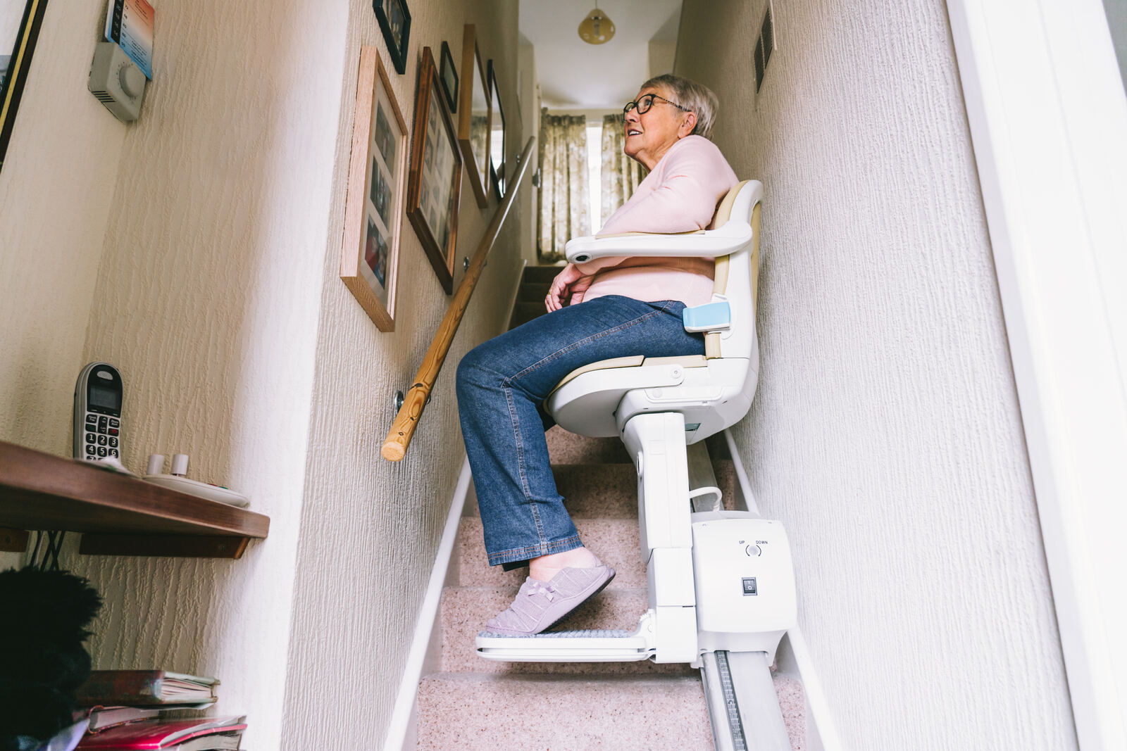 A stairlift fitted on a carpeted staircase in a British home